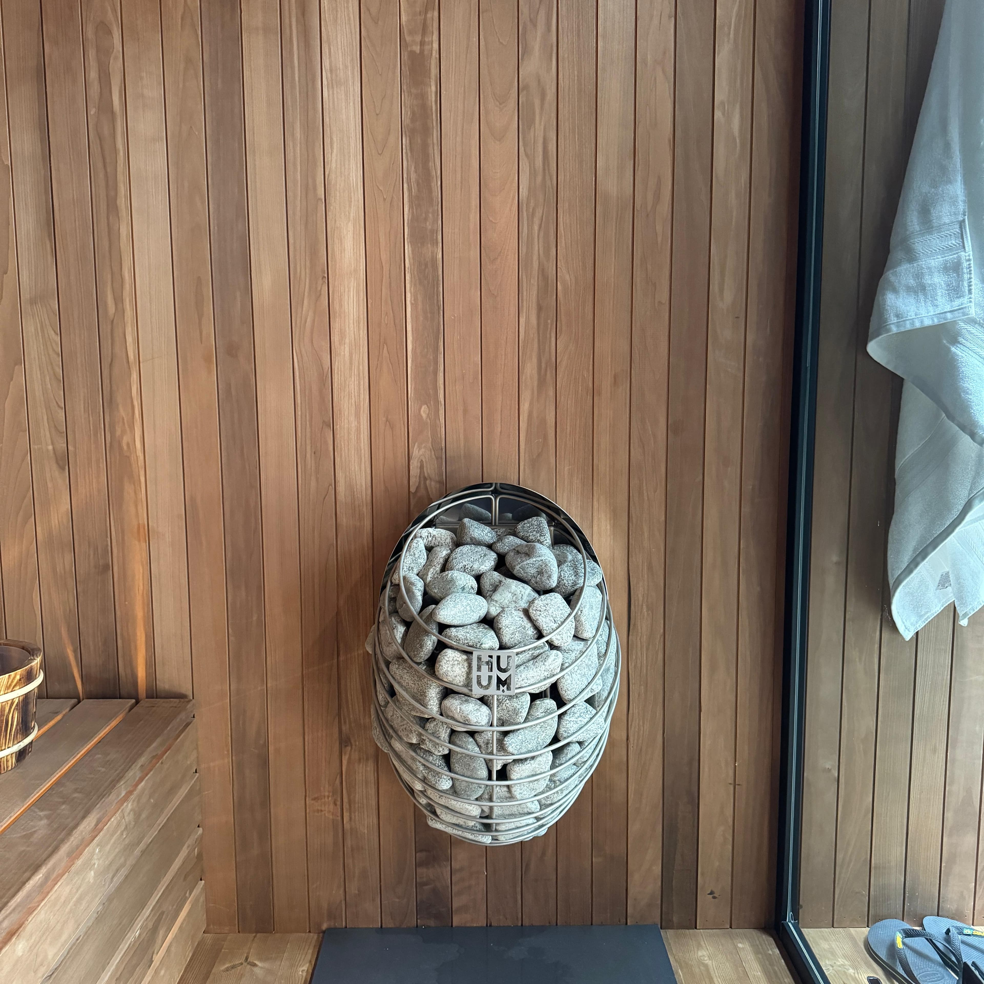 HUUM electric heater inside a compact outdoor cube sauna
