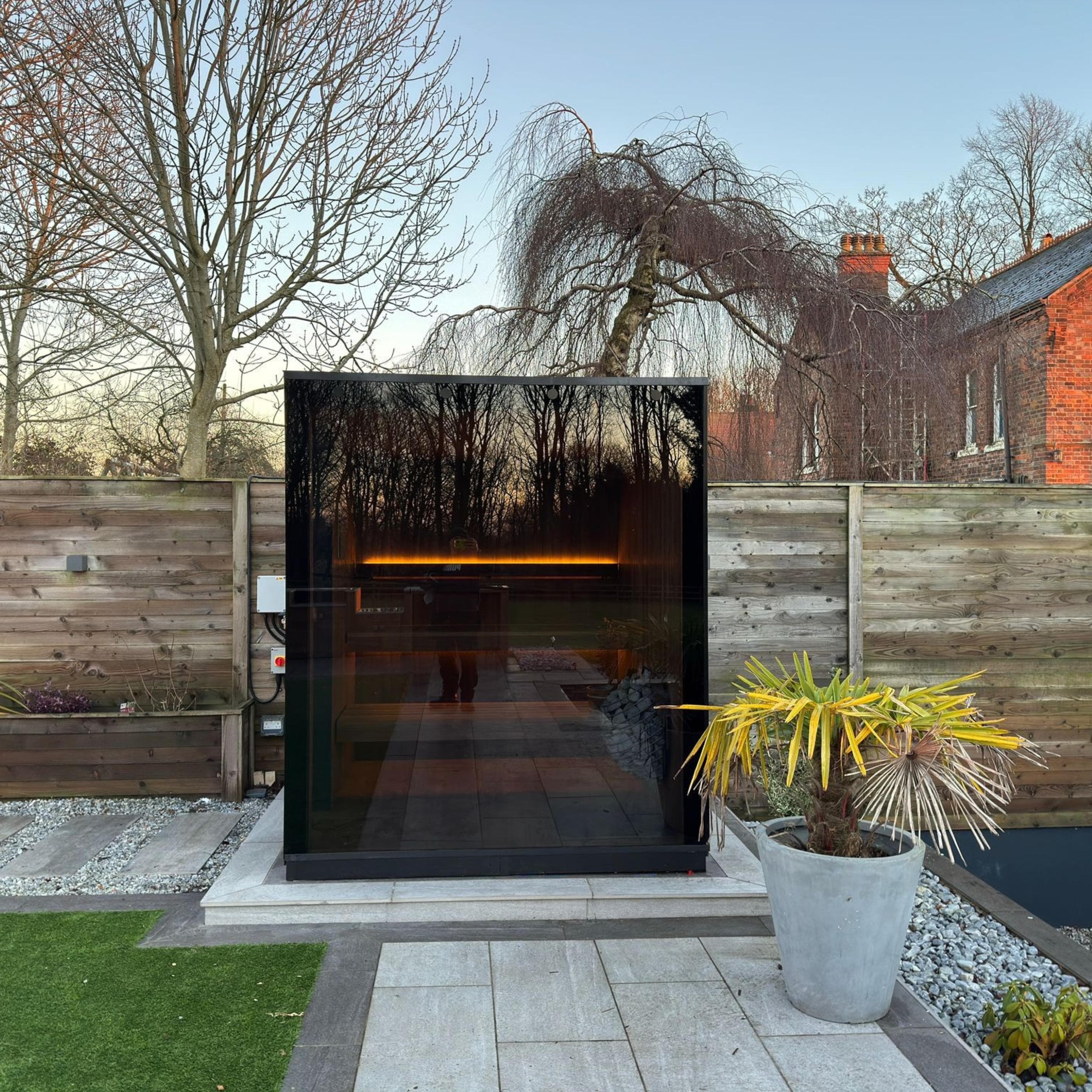 Modern wooden cube sauna with panoramic glass front – Wood Architects